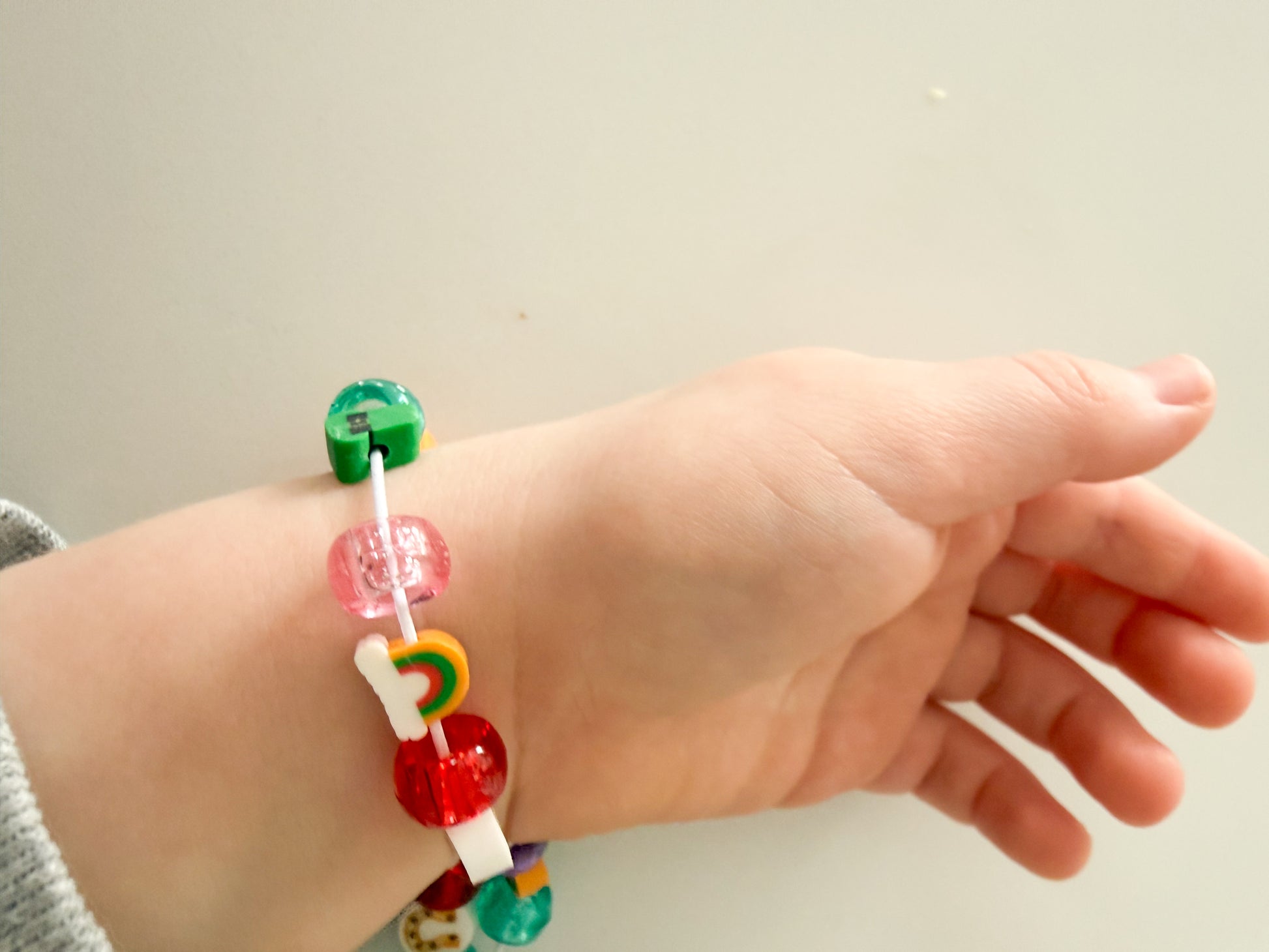 Child wearing handmade lucky charm bracelet from St. Patrick’s Day activity kit