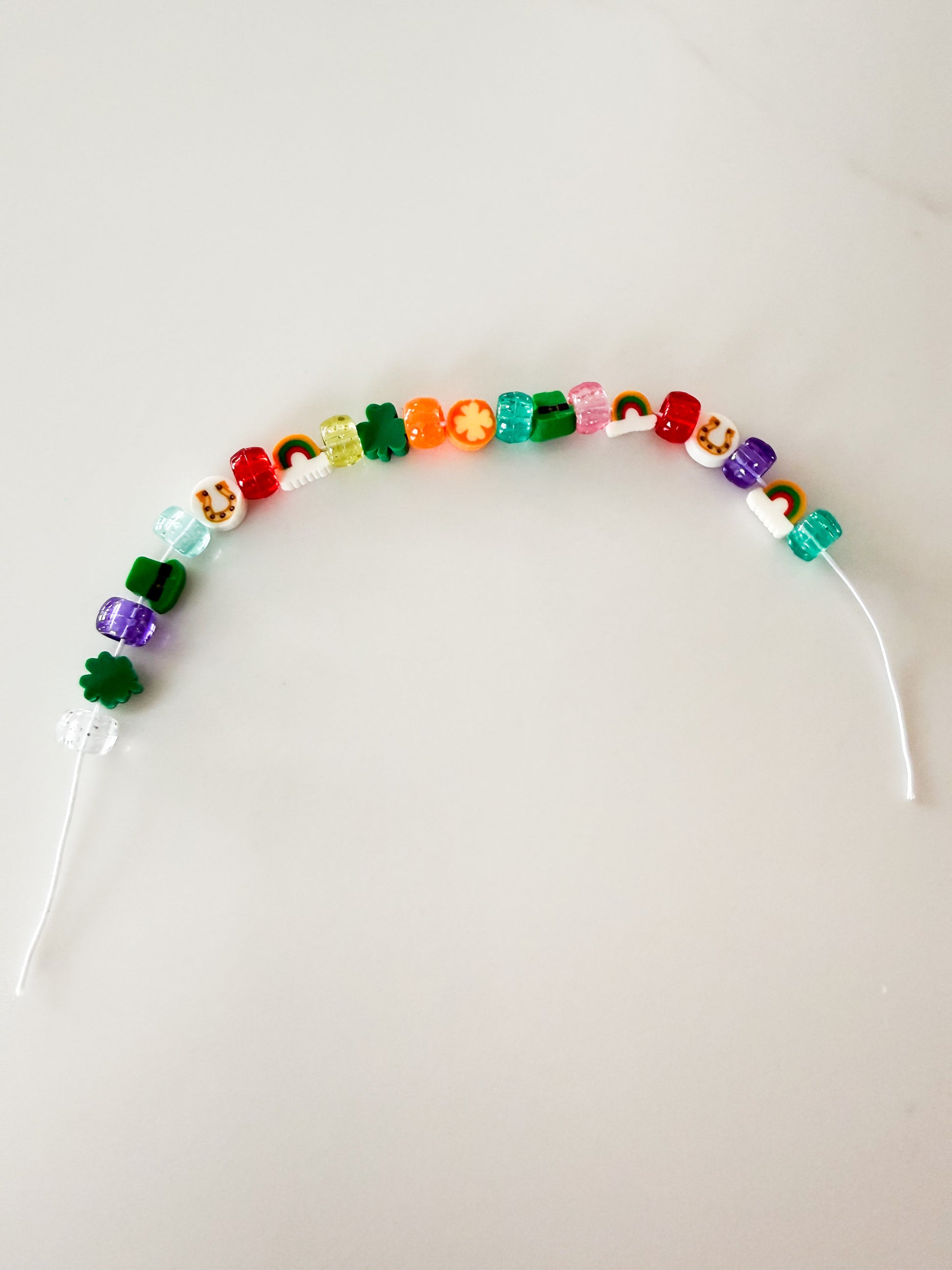 Lucky charm bracelet craft with beads and string included in St. Patrick’s Day activity kit for kids